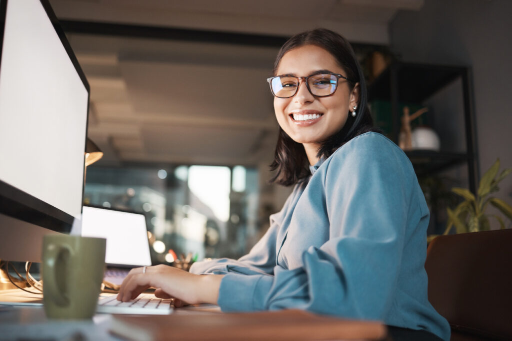 a girl smiling working on her computer