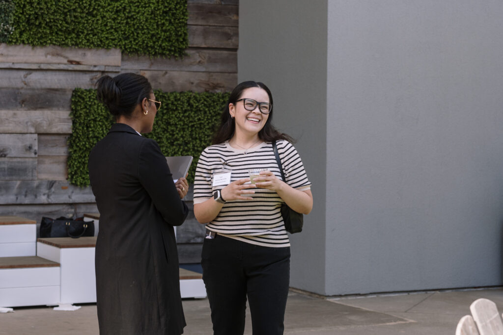 A Roam event with two coworkers laughing and networking.