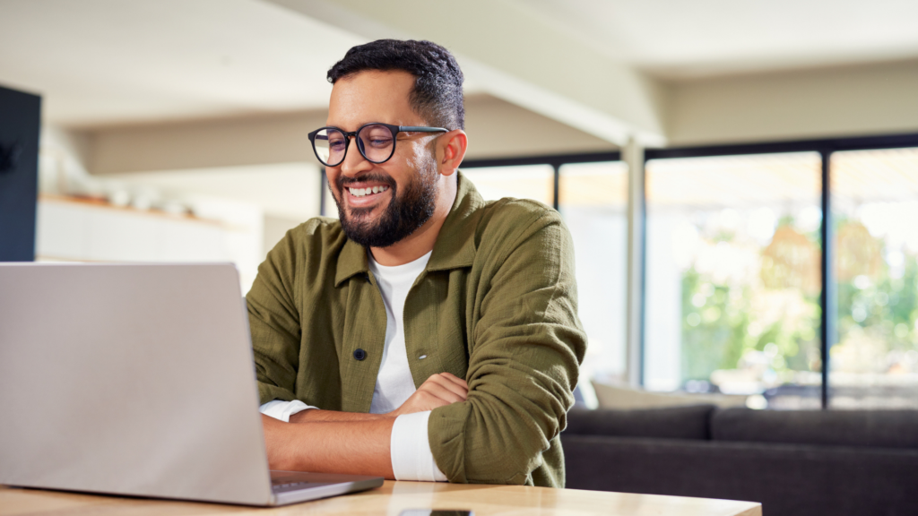 Man smiling at computer on virtual meeting